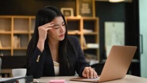 Frustration female entrepreneur holding her head, thinking find solution problem of work.