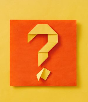 Layered orange and yellow background with origami question mark Layered orange and yellow background with origami question mark